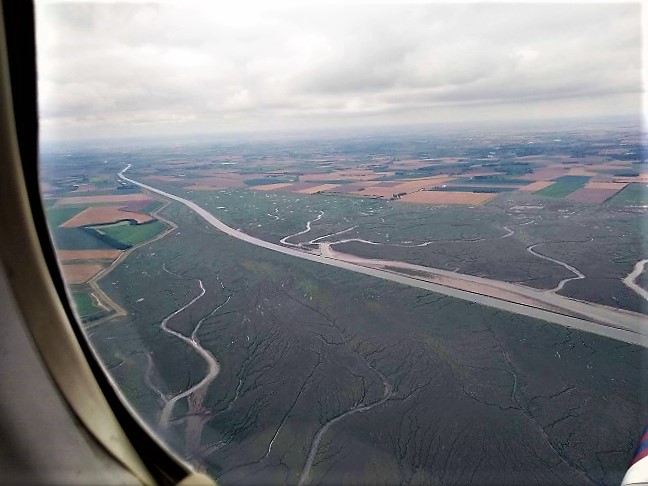 View of the mud flats and waterways alongside The Wash from about 2000ft