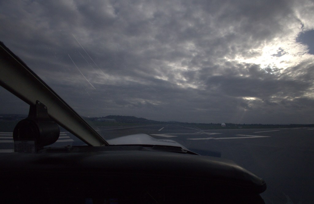View down the runway with dark clouds above