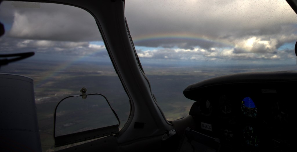 View from the plane of a rainbow alongside